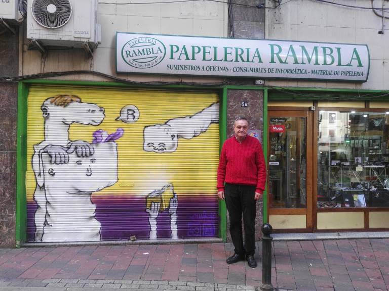 El presidente de la Asociación de Comerciantes junto al mural de la papelería Rambla