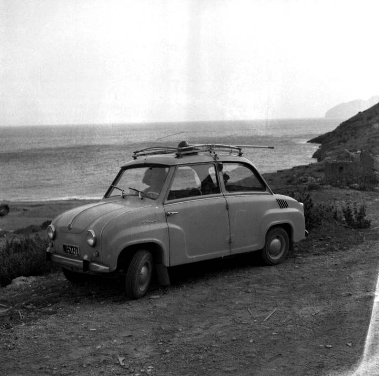 Utilitario Goggomobil estacionado junto a una playa desierta